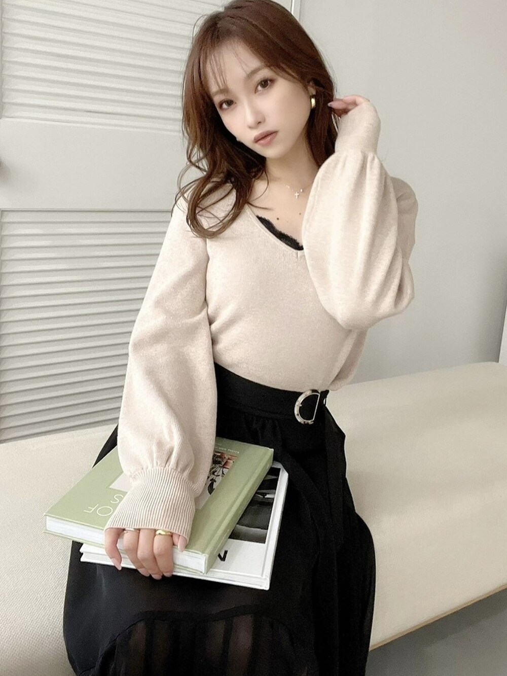 ブラック系のパンプス、ブラック系のスカート、ベージュ系のニット/セーターを着用したレディースの秋コーディネートの2枚目の写真