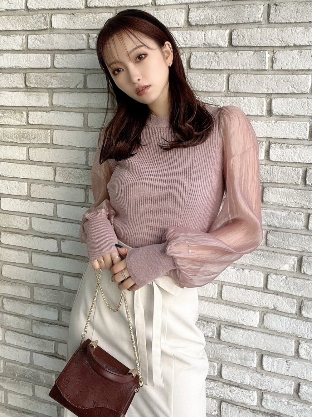 ホワイト系のスカート、ピンク系のニット/セーター、ブラック系のカチューシャを着用したレディースの秋コーディネートの2枚目の写真