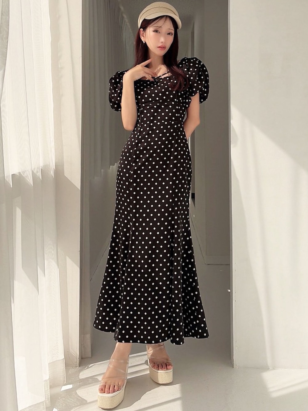 ブラック系のワンピース、ホワイト系のサンダルを着用したレディースの春コーディネートの3枚目の写真