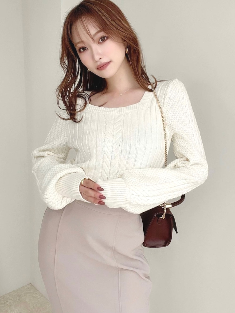 ホワイト系のニット/セーター、ベージュ系のスカート、ホワイト系のブーツを着用したレディースの秋コーディネートの4枚目の写真