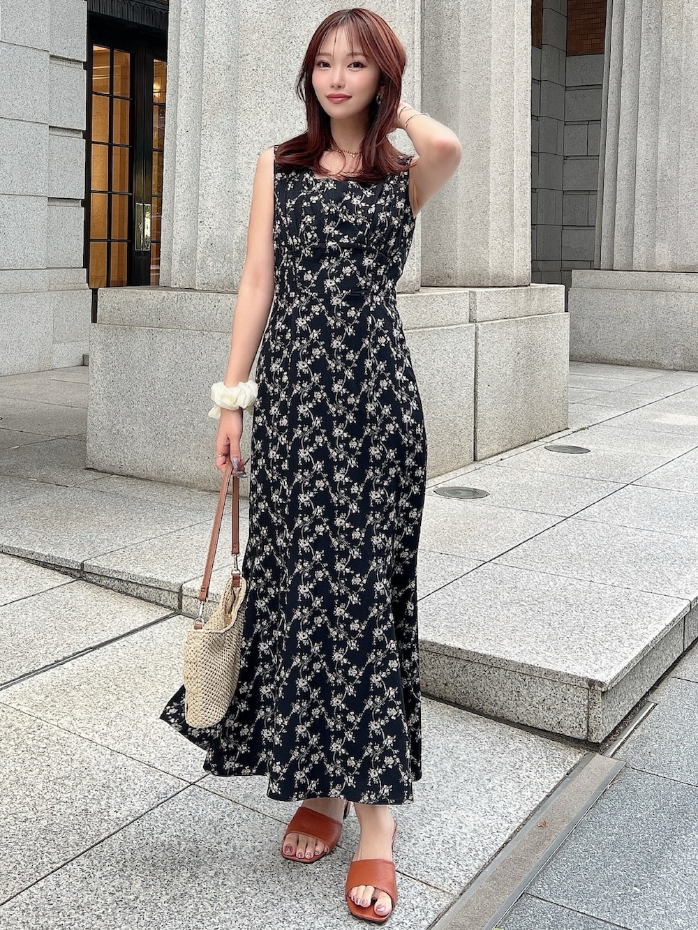 ブラック系のワンピース、ベージュ系のハンドバッグを着用したレディースの夏コーディネートの2枚目の写真