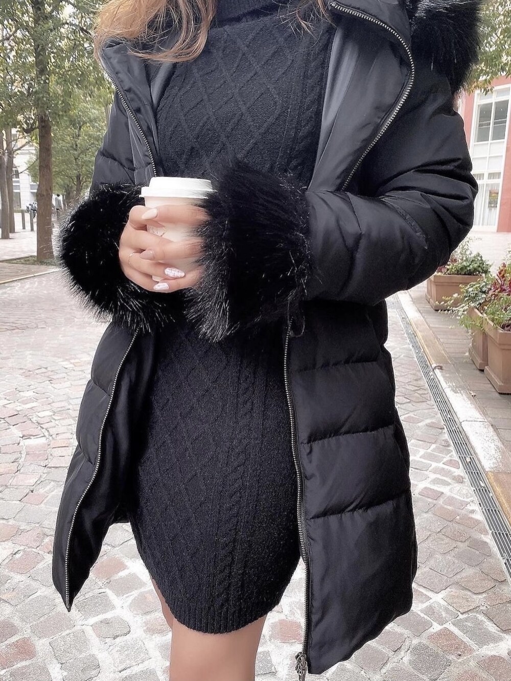 ブラック系のワンピース、ブラック系のダウンジャケット/コート、ブラウン系のブーツを着用したレディースの秋コーディネートの2枚目の写真