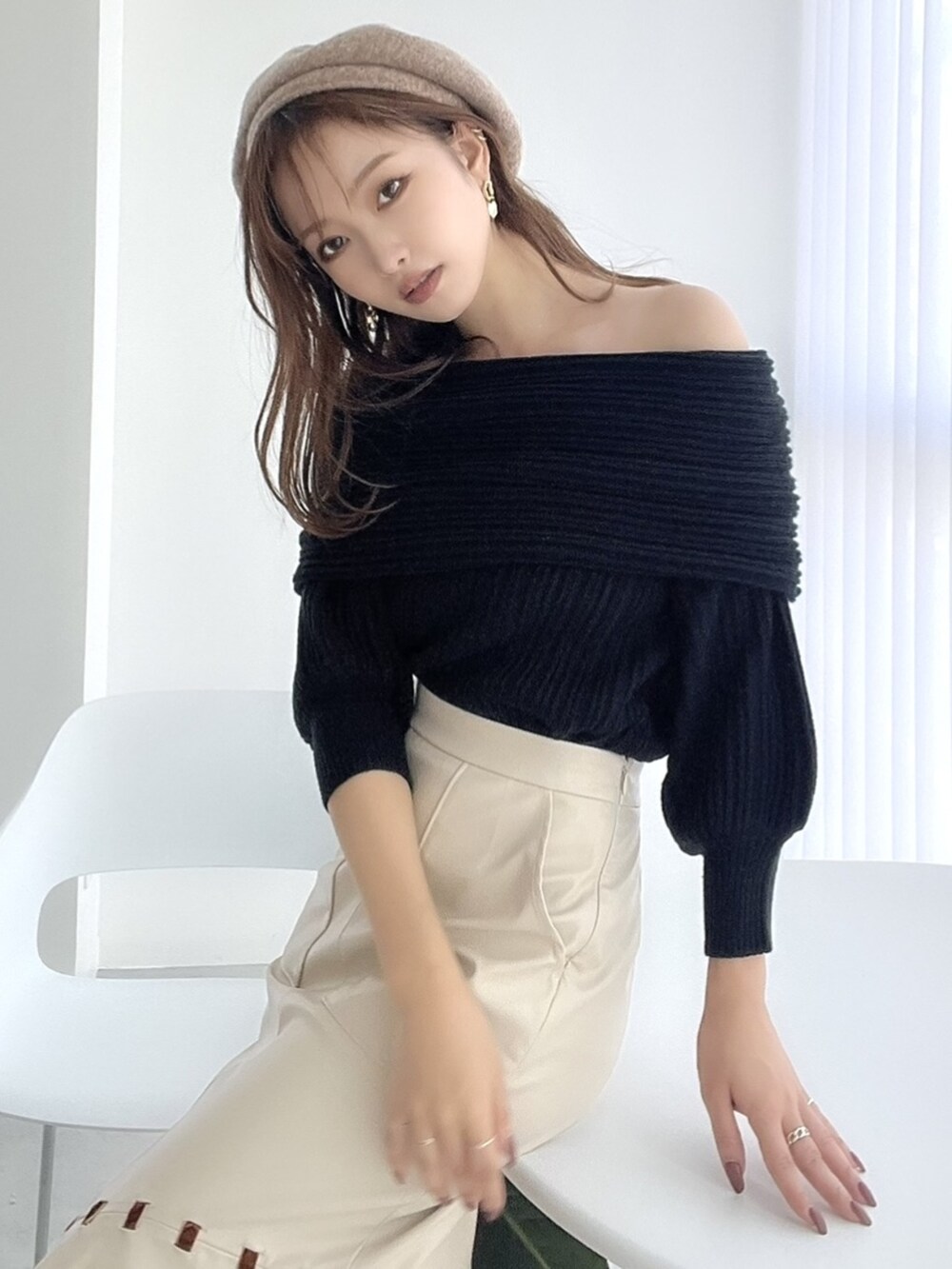 ブラック系のニット/セーター、ベージュ系のスカート、ベージュ系のハンチング/ベレー帽を着用したレディースの夏コーディネートの2枚目の写真