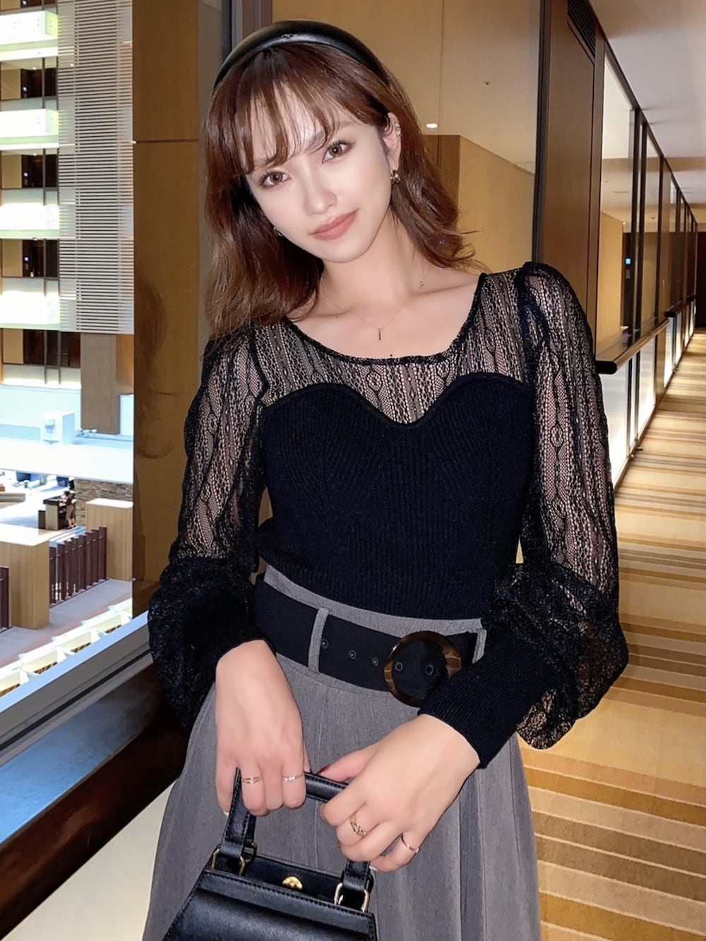 ブラウン系のブーツ、ブラック系のニット/セーター、ブラック系のスカートを着用したレディースの冬コーディネートの2枚目の写真