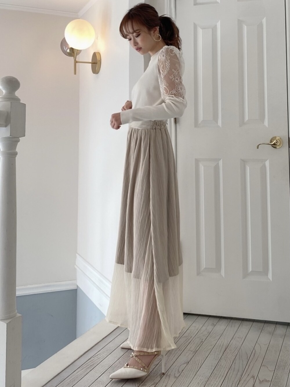 ベージュ系のスカート、ホワイト系のパンプスを着用したレディースの冬コーディネートの2枚目の写真