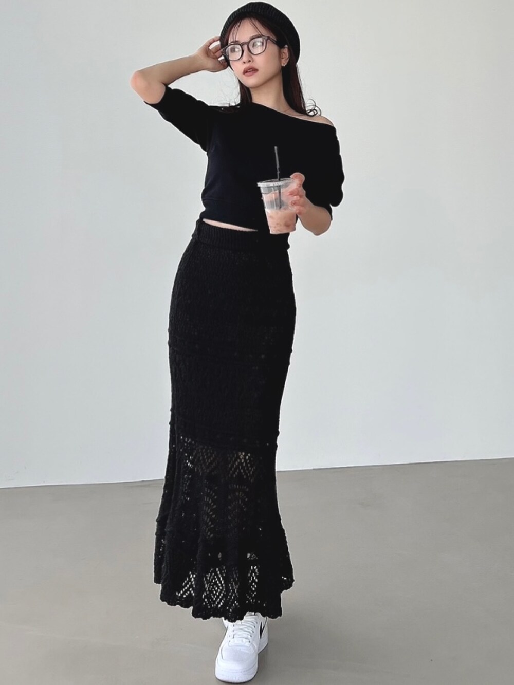 ブラック系のスウェット、ブラック系のスカートを着用したレディースの春コーディネートの3枚目の写真