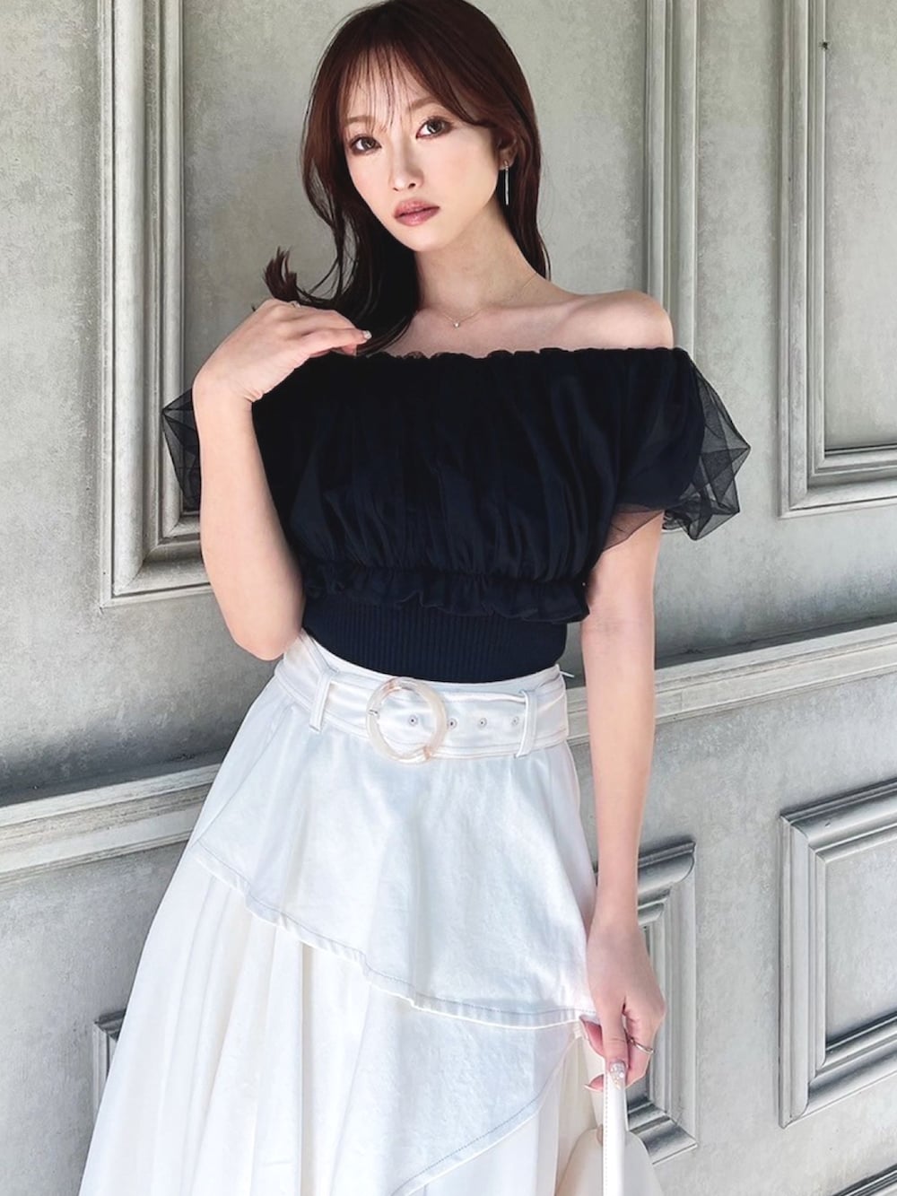 ホワイト系のパンプス、ホワイト系のデニムスカート、ブラック系のシャツ/ブラウスを着用したレディースの冬コーディネートの4枚目の写真