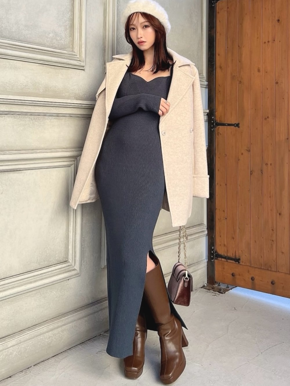 ホワイト系のトレンチコート、グリーン系のワンピース、ブラウン系のブーツを着用したレディースの冬コーディネートの2枚目の写真