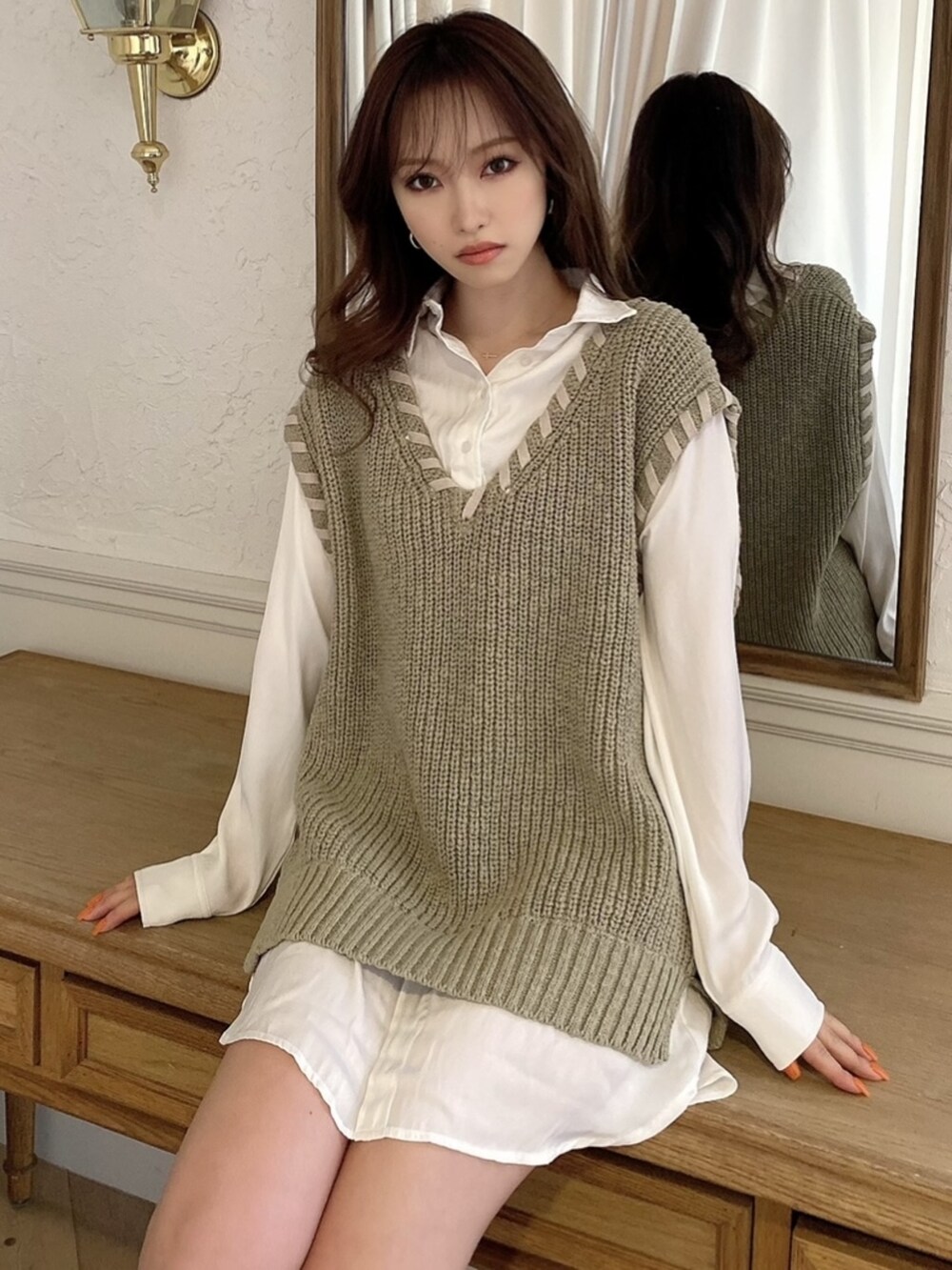 グリーン系のベストを着用したレディースの春コーディネートの4枚目の写真