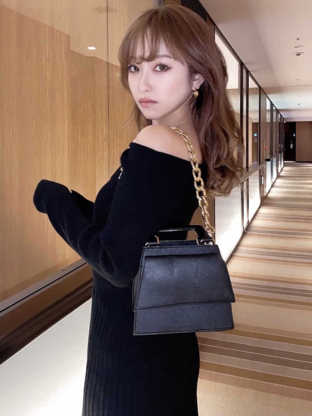 ブラック系のワンピース、ブラック系のパンプスを着用したレディースの冬コーディネートの2枚目の写真