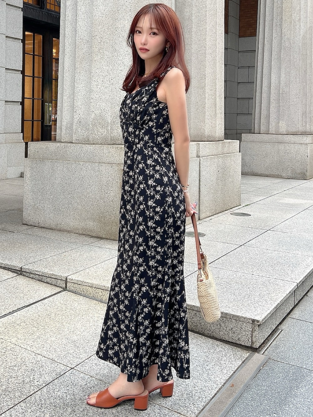 ブラック系のワンピース、ベージュ系のハンドバッグを着用したレディースの夏コーディネートの3枚目の写真