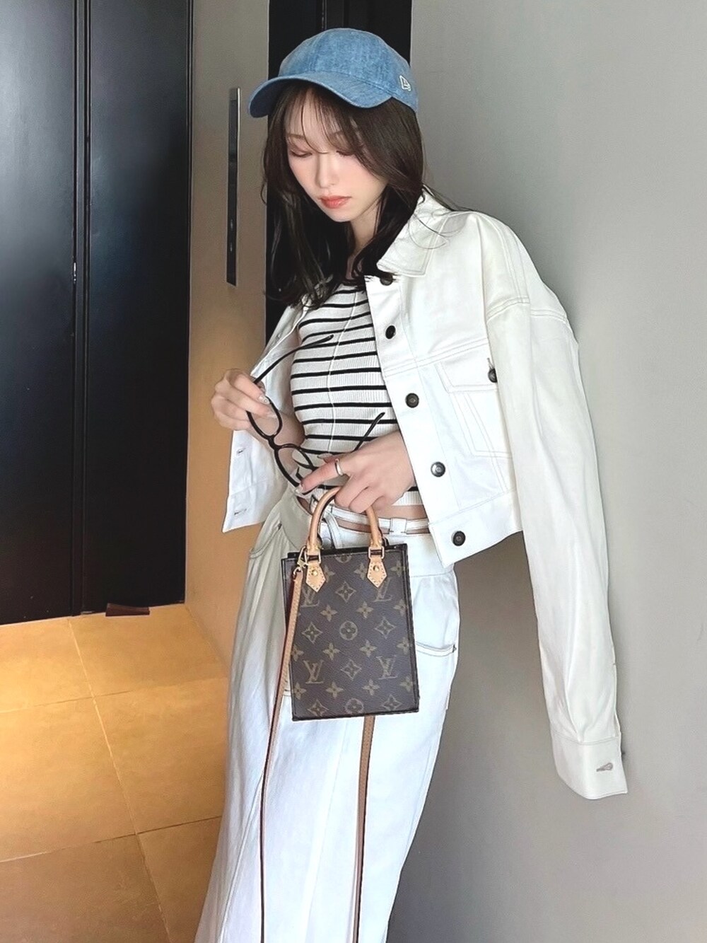 ホワイト系のデニムジャケット、ホワイト系のデニムスカートを着用したレディースの春コーディネートの2枚目の写真