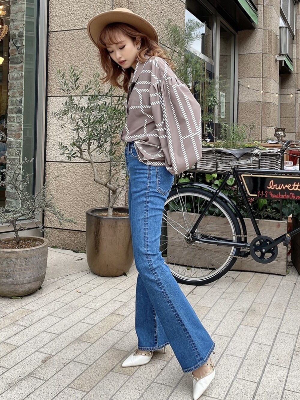 ブルー系のデニムパンツ、ホワイト系のパンプス、ベージュ系のハットを着用したレディースの冬コーディネートの3枚目の写真