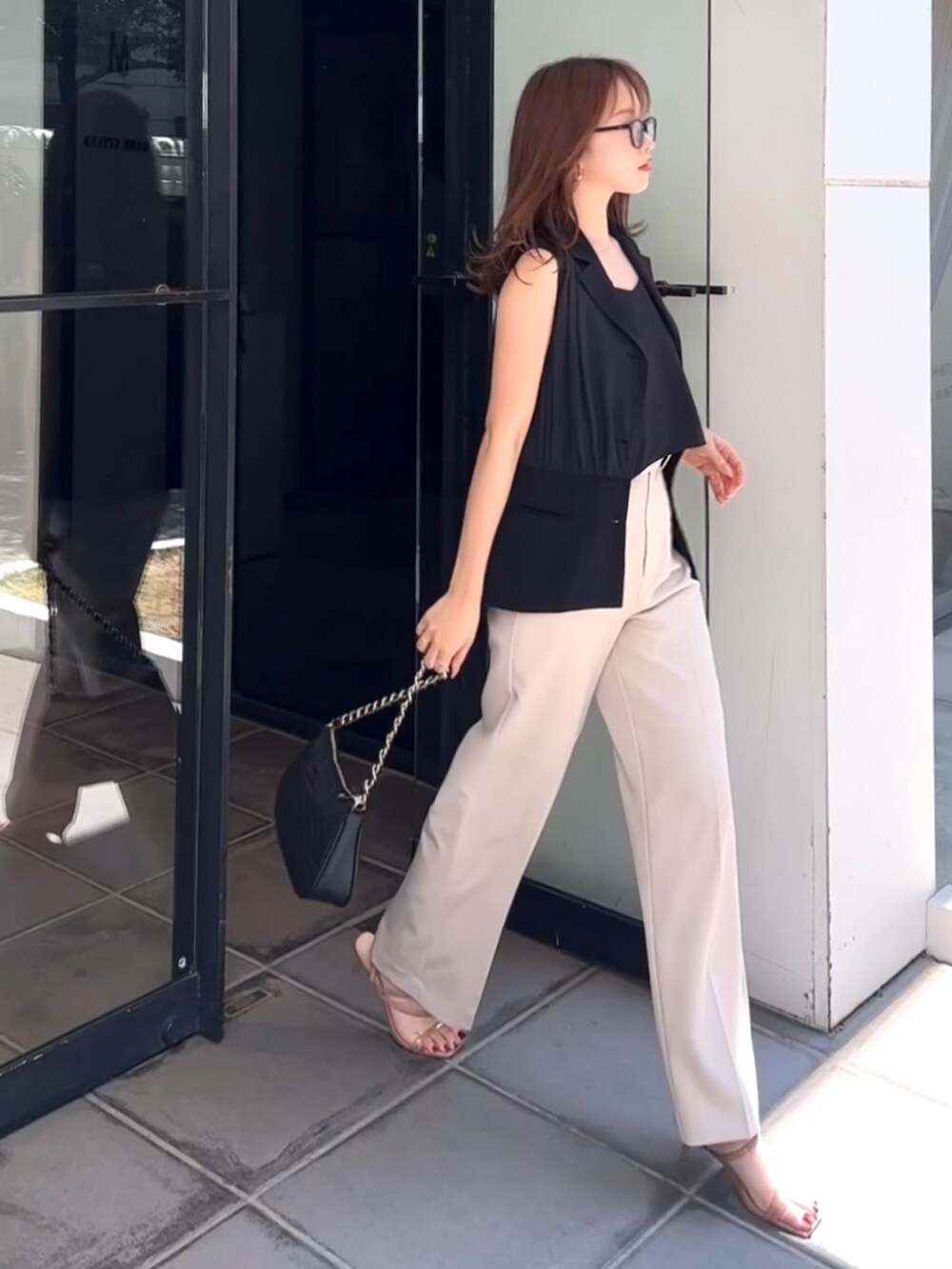 ブラック系のテーラードジャケット、ブラック系のキャミソール、ホワイト系のその他パンツを着用したレディースの夏コーディネートの3枚目の写真