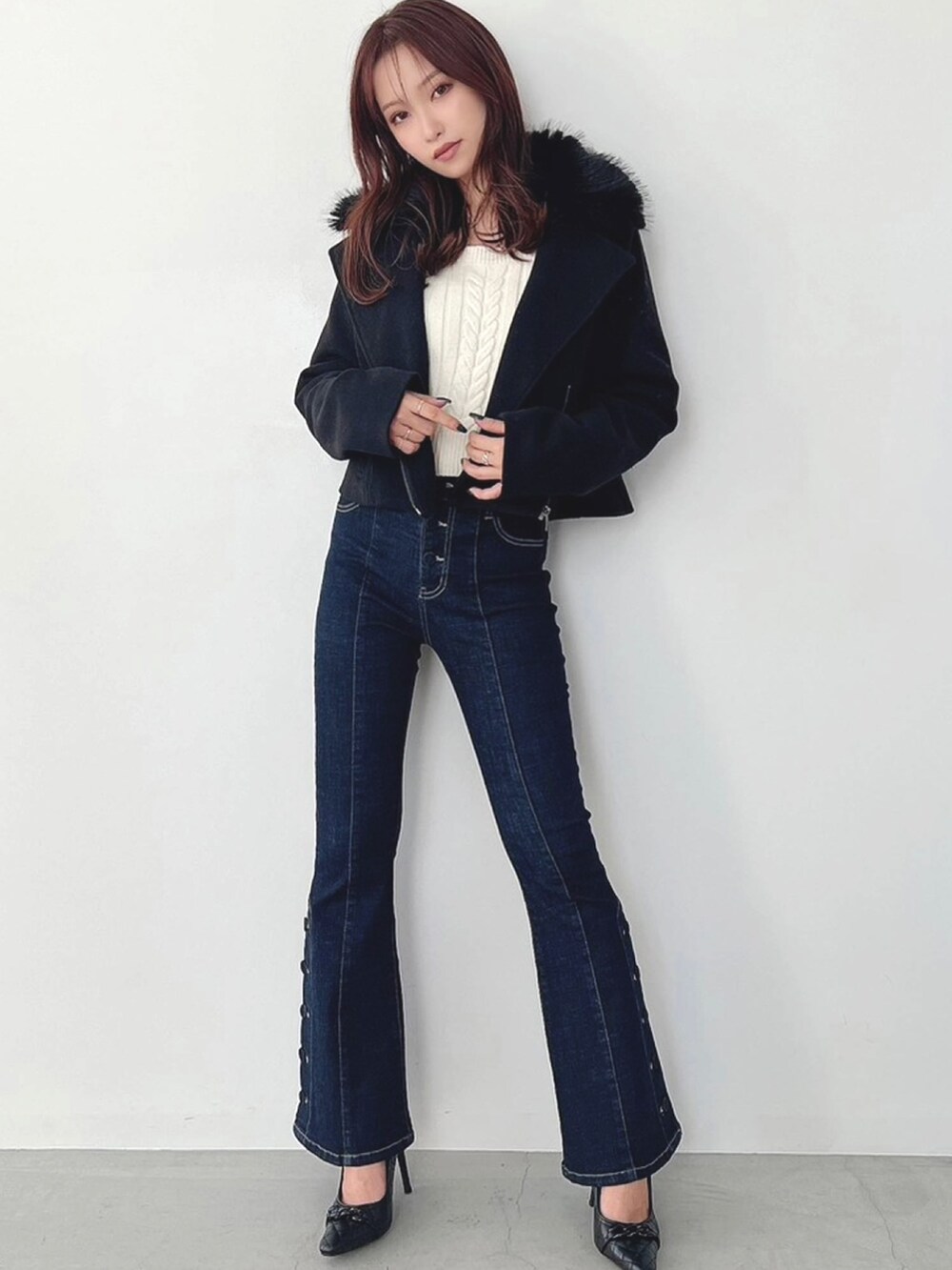 ブルー系のデニムパンツ、ホワイト系のニット/セーター、ブラック系のその他アウターを着用したレディースの秋コーディネートの2枚目の写真