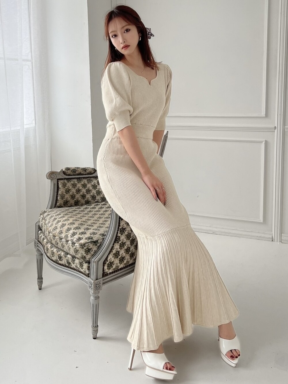 ベージュ系のワンピース、ホワイト系のパンプス、ブラック系のショルダーバッグを着用したレディースの春コーディネートの4枚目の写真