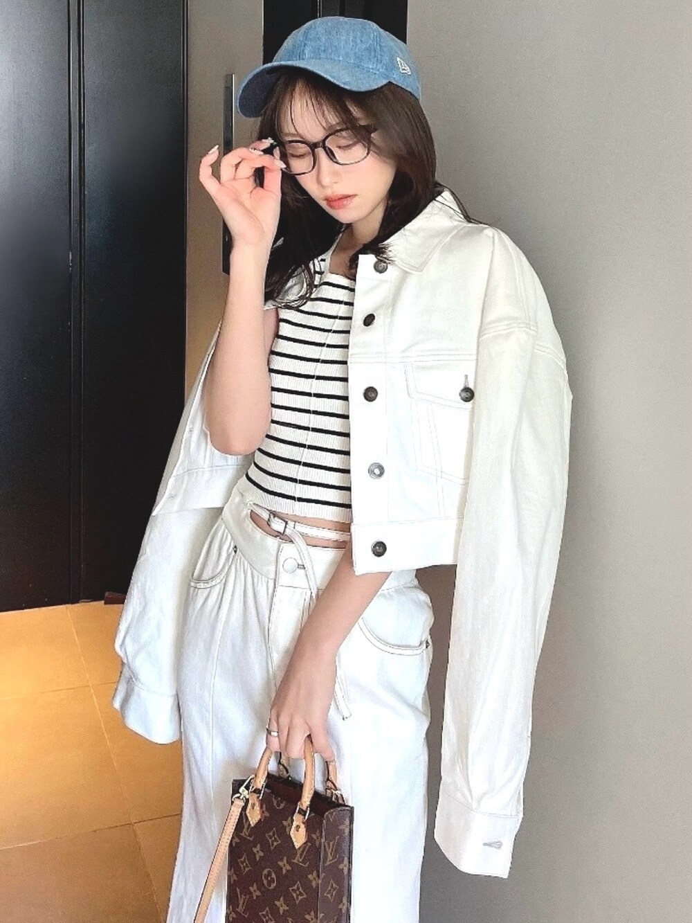 ホワイト系のデニムジャケット、ホワイト系のデニムスカートを着用したレディースの春コーディネートの3枚目の写真