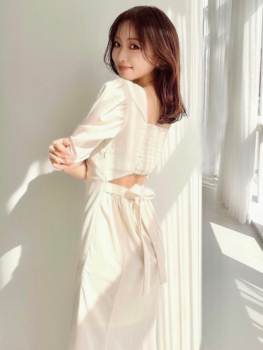 ホワイト系のワンピース、ホワイト系のサンダルを着用したレディースの春コーディネートの3枚目の写真