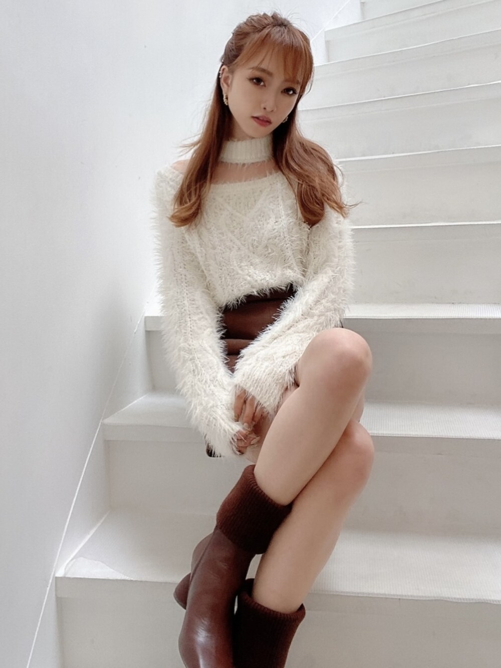 ホワイト系のニット/セーター、ブラウン系のその他パンツ、ブラウン系のブーツを着用したレディースの夏コーディネートの2枚目の写真