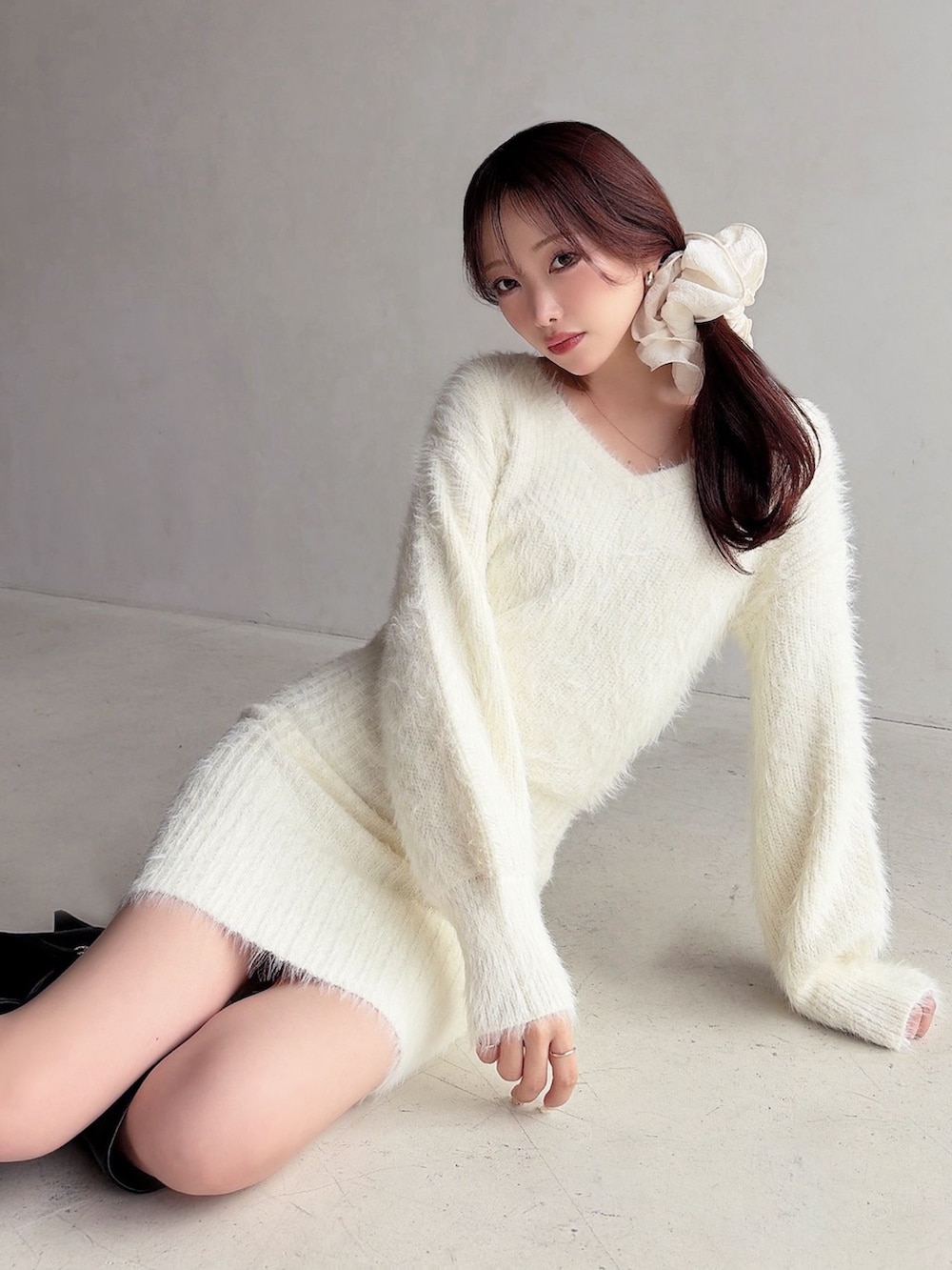 ホワイト系のワンピース、ブラック系のブーツを着用したレディースの冬コーディネートの4枚目の写真