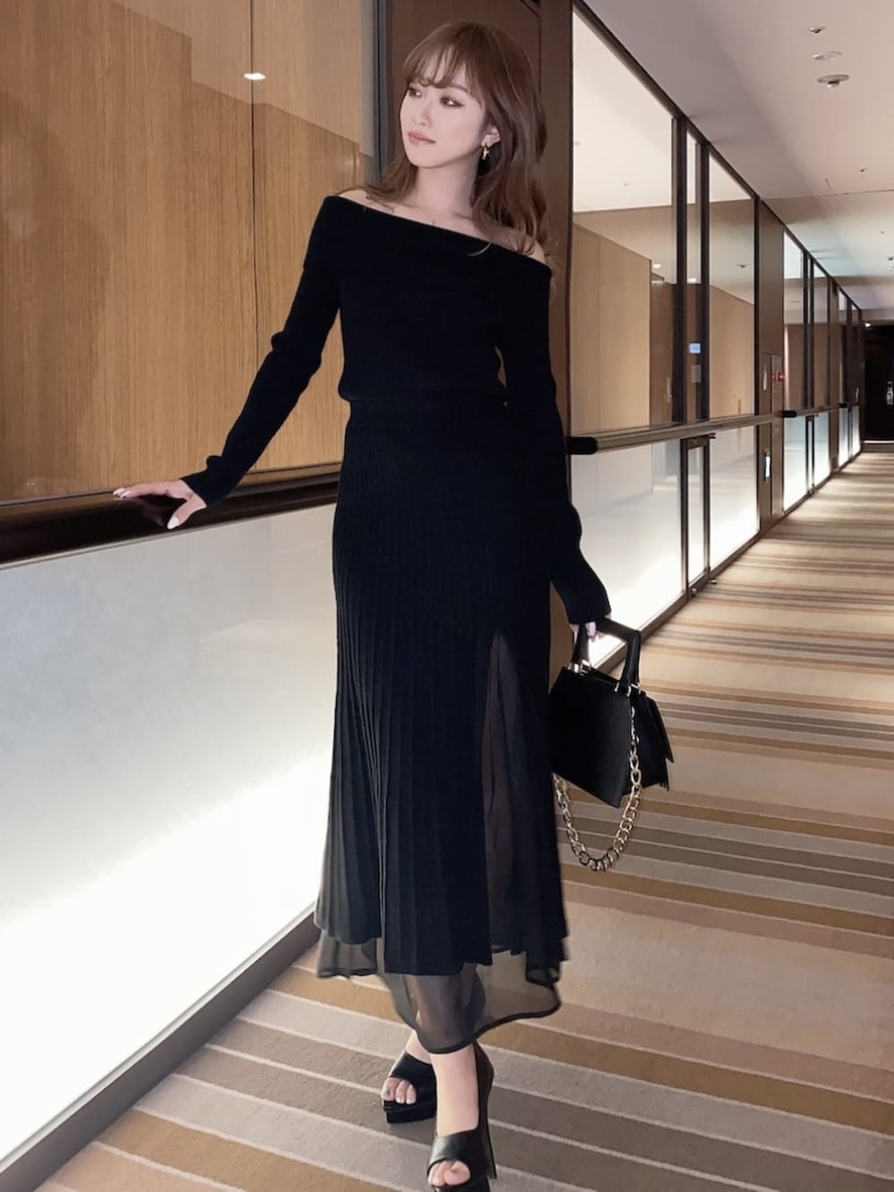 ブラック系のワンピース、ブラック系のパンプスを着用したレディースの冬コーディネートの5枚目の写真