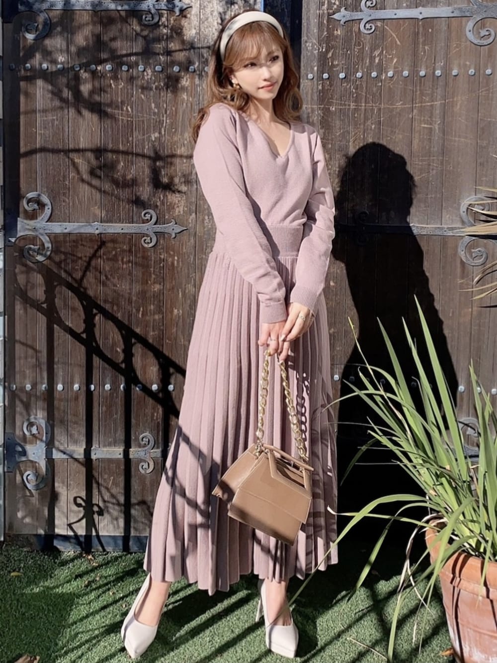 ベージュ系のワンピース、ホワイト系のパンプス、ベージュ系のカチューシャを着用したレディースの冬コーディネートの3枚目の写真