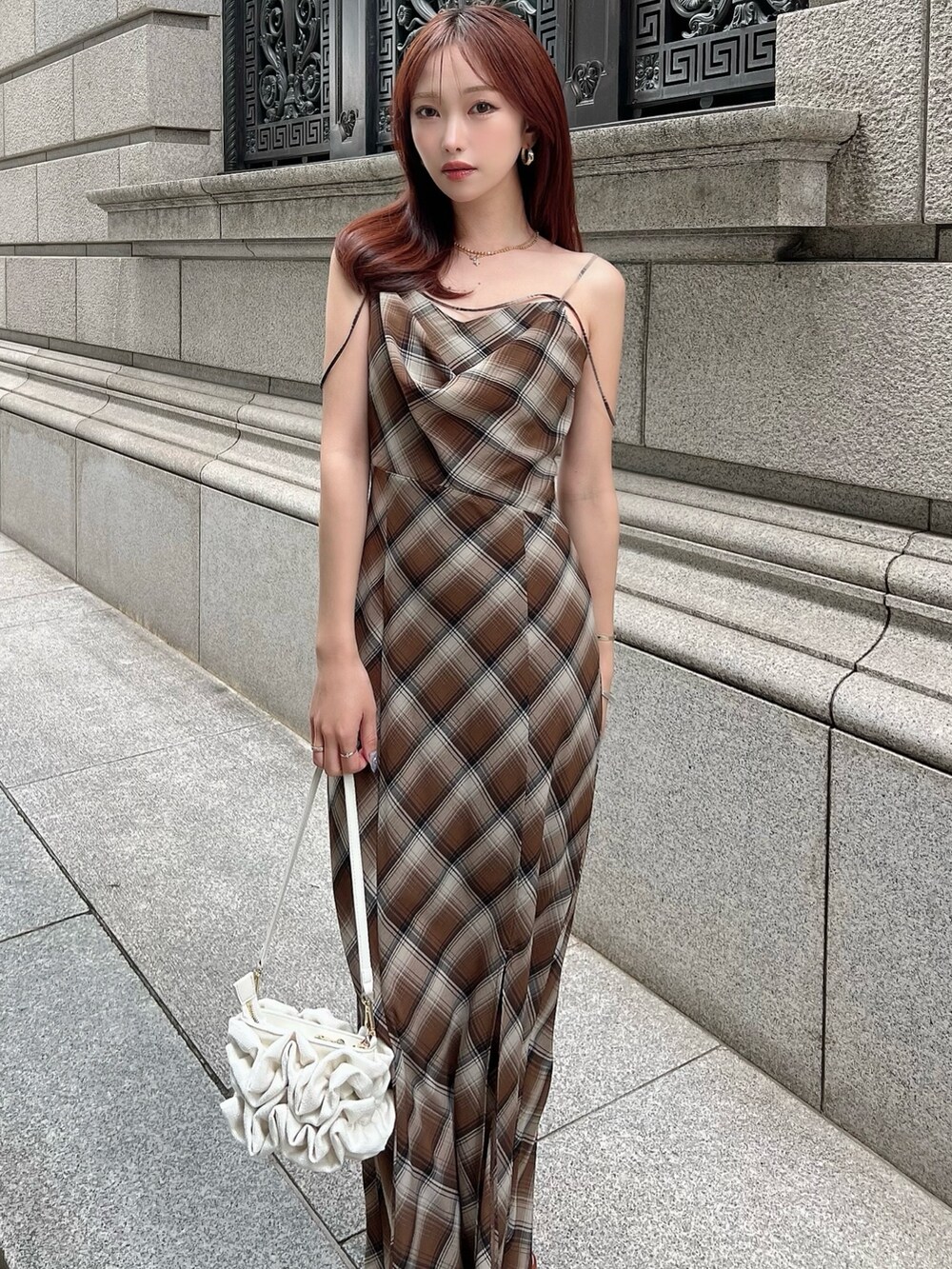 ブラウン系のワンピース、ホワイト系のハンドバッグを着用したレディースの夏コーディネートの4枚目の写真