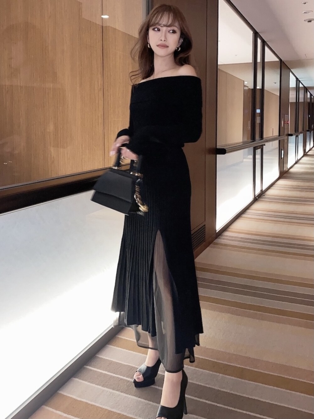 ブラック系のワンピース、ブラック系のパンプスを着用したレディースの冬コーディネートの4枚目の写真