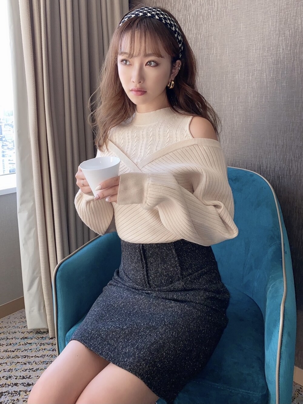 ホワイト系のニット/セーター、ブラック系のスカート、ブラック系のカチューシャを着用したレディースの秋コーディネートの2枚目の写真