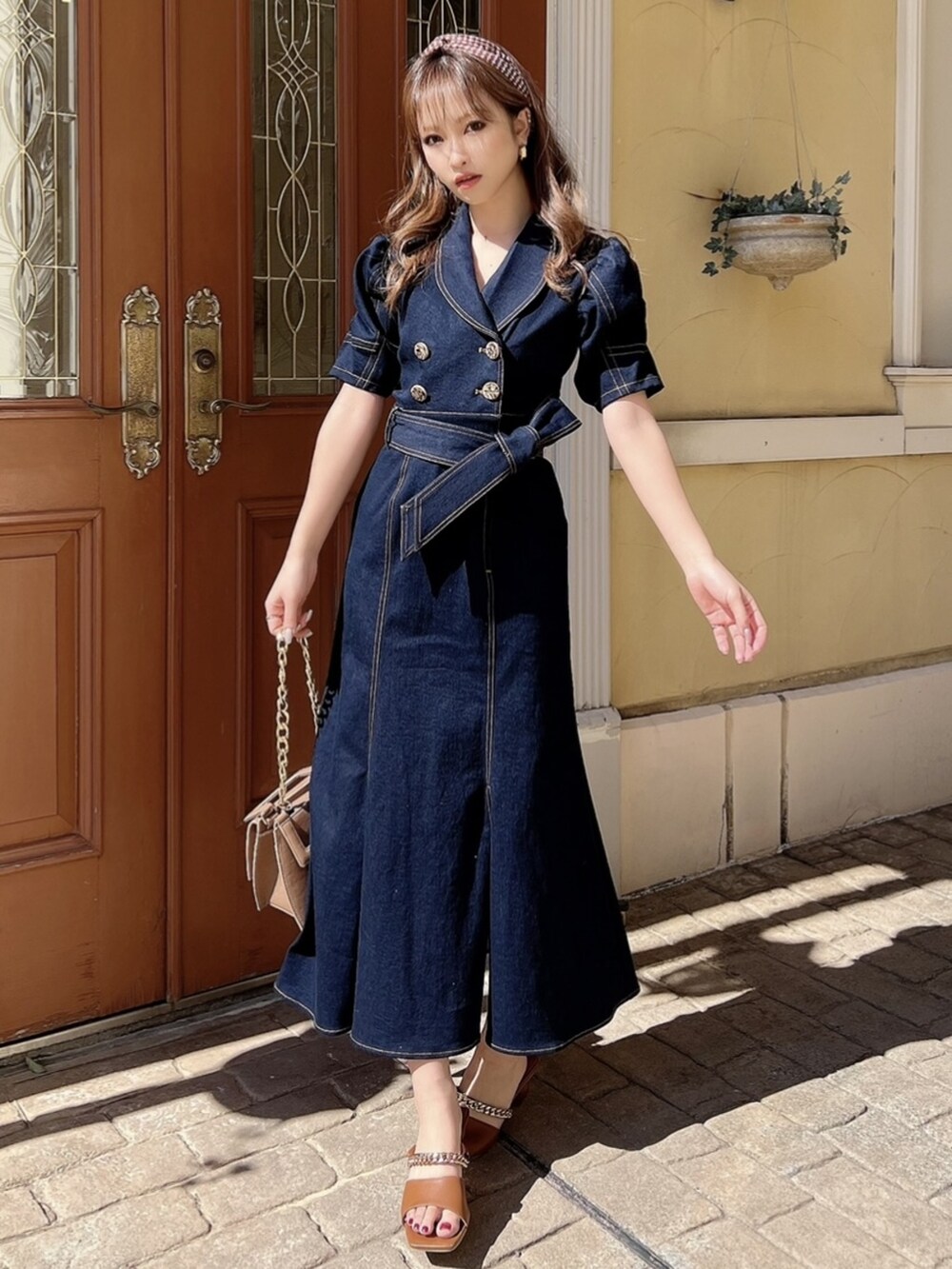 ブラウン系のサンダル、ブルー系のワンピース、ブラウン系のショルダーバッグを着用したレディースの春コーディネートの2枚目の写真