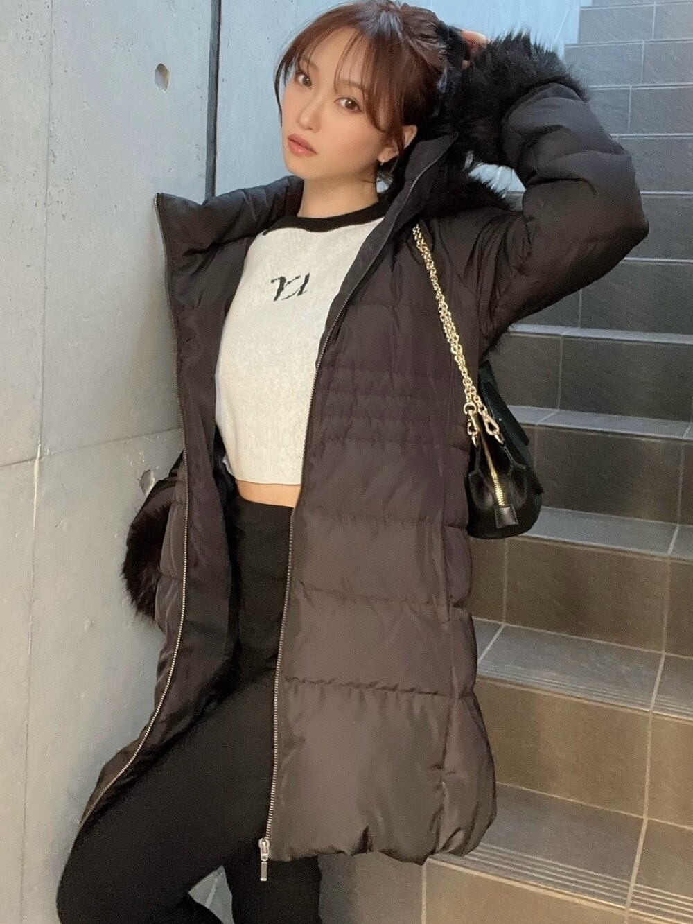 ブラック系のダウンジャケット/コート、グレー系のニット/セーター、ブラック系のブーツを着用したレディースの秋コーディネートの3枚目の写真