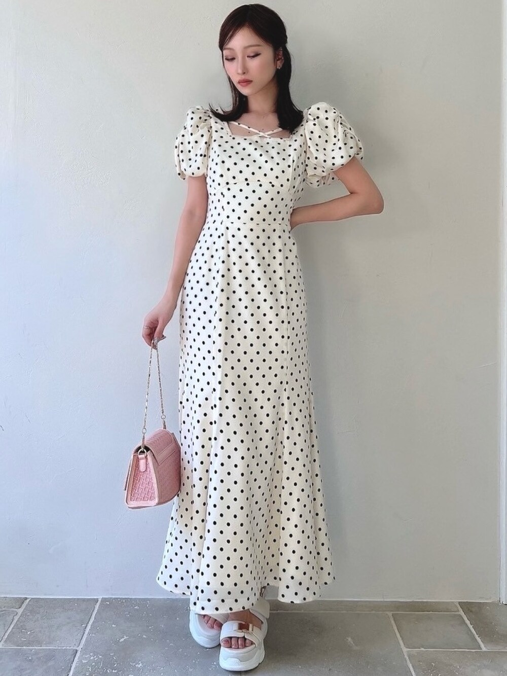 ホワイト系のワンピース、ホワイト系のサンダル、ピンク系のハンドバッグを着用したレディースの春コーディネートの4枚目の写真