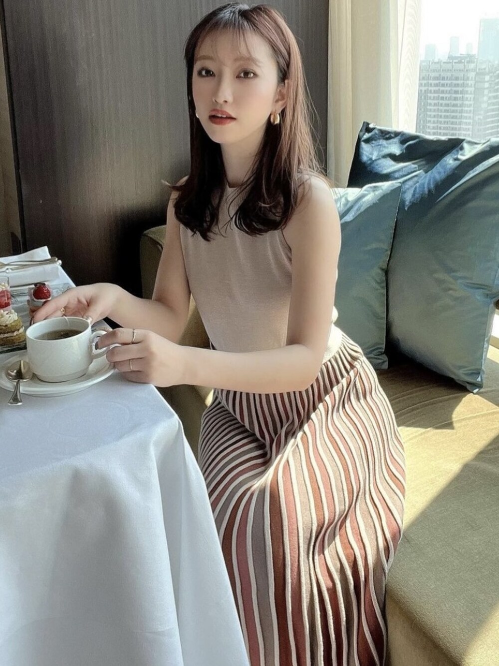 ベージュ系のワンピースを着用したレディースの春コーディネートの2枚目の写真