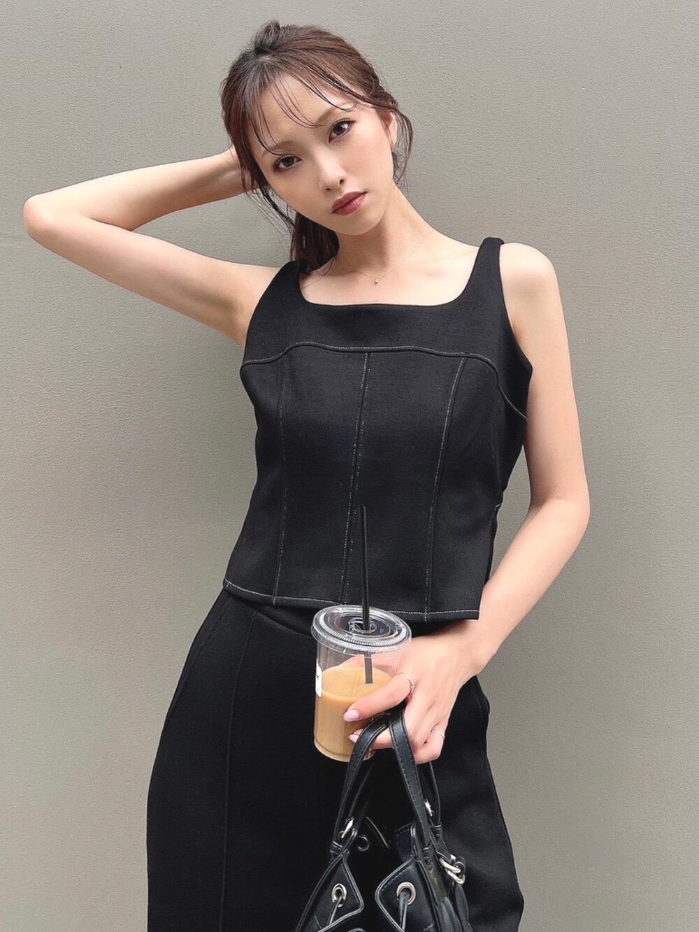 ブラック系のスウェット、ブラック系のスウェットパンツ、ブラック系のハンドバッグを着用したレディースの夏コーディネートの4枚目の写真