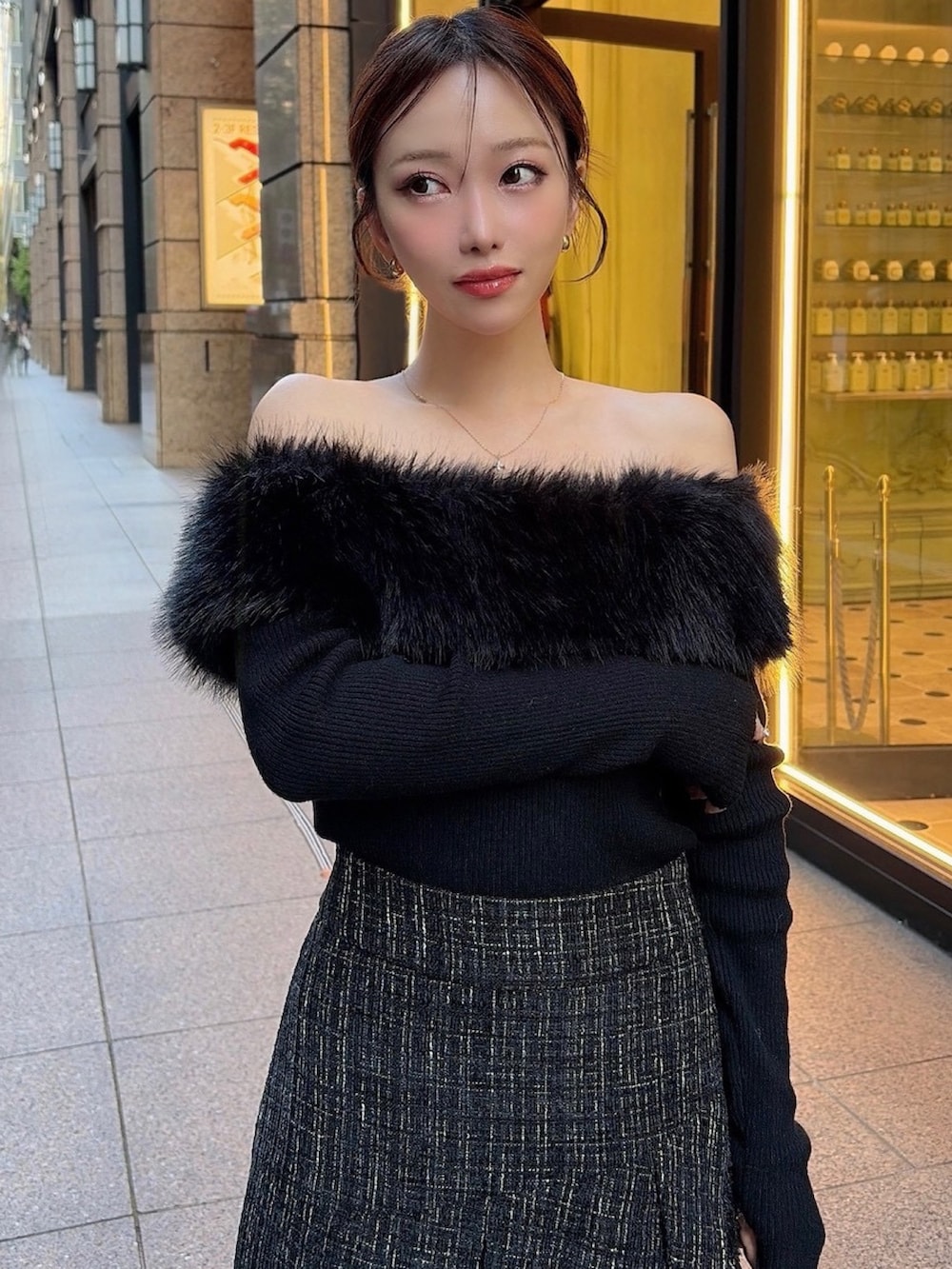 ブラック系のニット/セーター、ブラック系のスカート、ブラック系のハンドバッグを着用したレディースの冬コーディネートの3枚目の写真