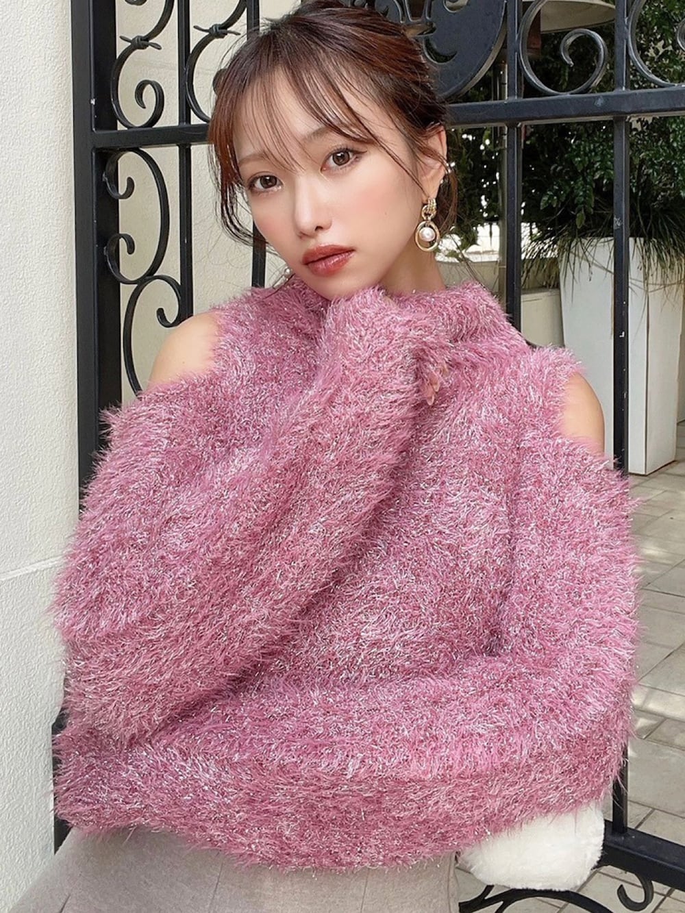 ピンク系のニット/セーター、ホワイト系のハンドバッグを着用したレディースの冬コーディネートの4枚目の写真