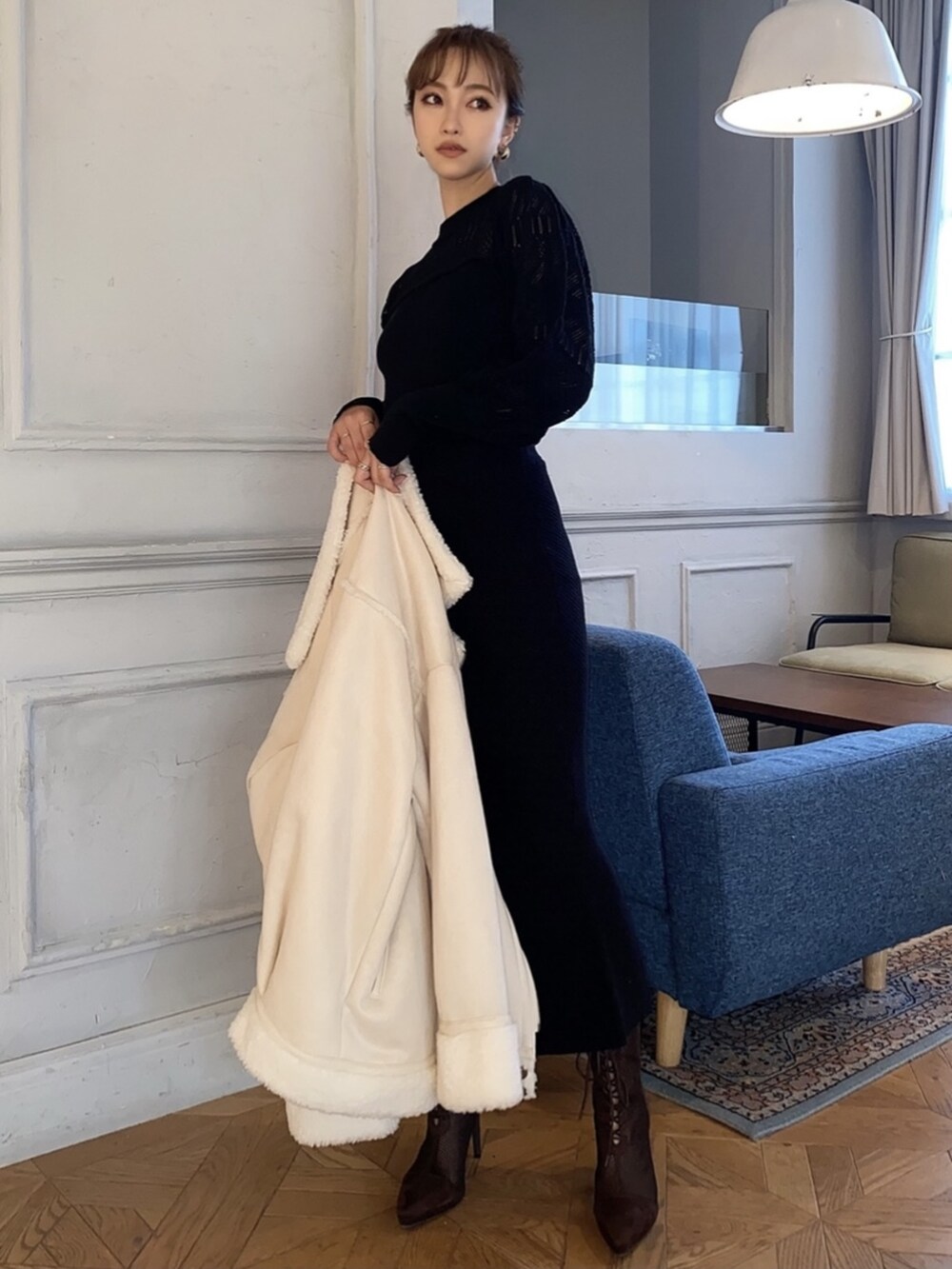 ブラック系のスカート、ブラック系のニット/セーター、ホワイト系のムートンコートを着用したレディースの冬コーディネートの6枚目の写真