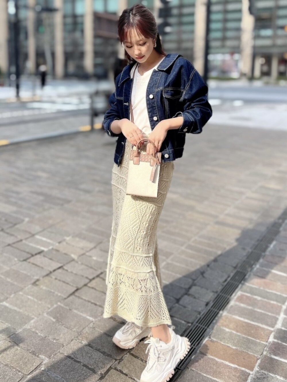 ピンク系のTシャツ/カットソー、ホワイト系のスカート、ブルー系のデニムジャケットを着用したレディースの春コーディネートの2枚目の写真