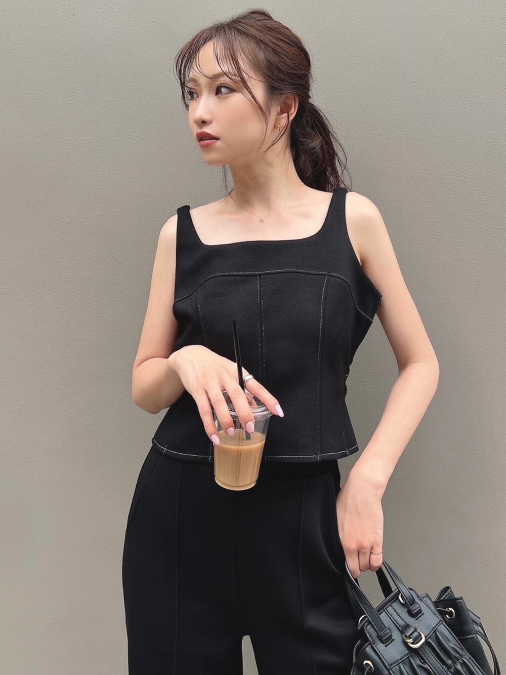 ブラック系のスウェット、ブラック系のスウェットパンツ、ブラック系のハンドバッグを着用したレディースの夏コーディネートの5枚目の写真