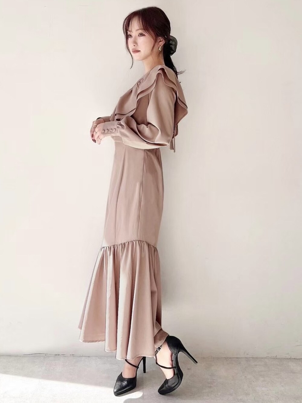 ブラック系のパンプス、ベージュ系のワンピースを着用したレディースの秋コーディネートの2枚目の写真