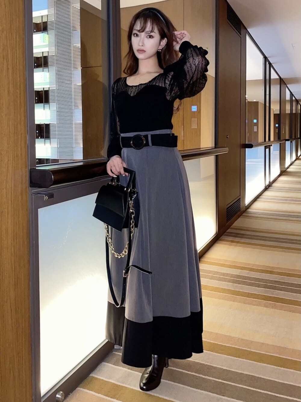 ブラウン系のブーツ、ブラック系のニット/セーター、ブラック系のスカートを着用したレディースの冬コーディネートの4枚目の写真