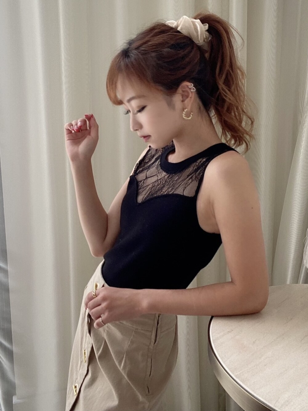 ブラック系のサンダル、ブラック系のニット/セーター、ベージュ系のスカートを着用したレディースの夏コーディネートの2枚目の写真