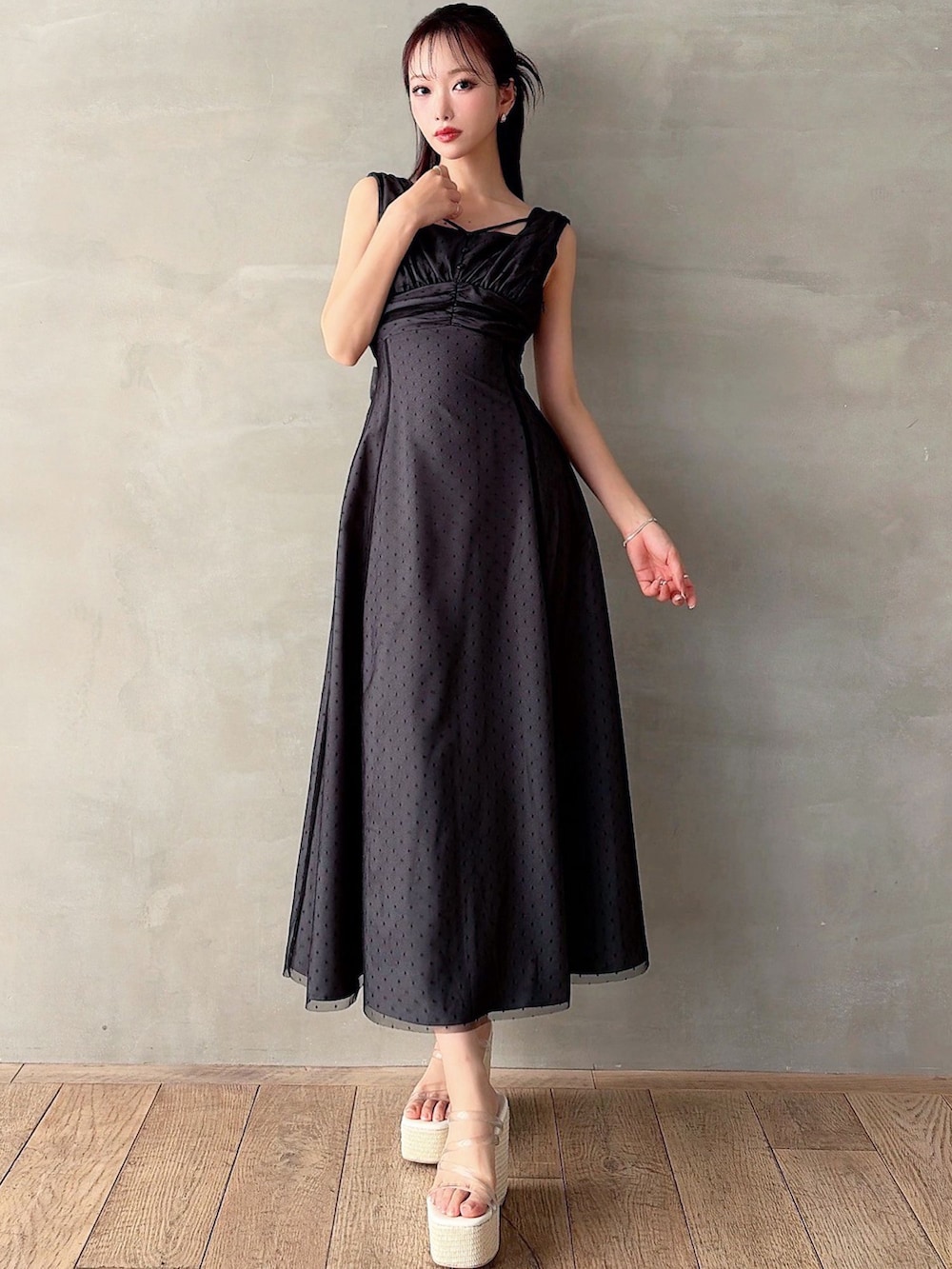 ブラック系のワンピース、ホワイト系のサンダルを着用したレディースの春コーディネートの3枚目の写真