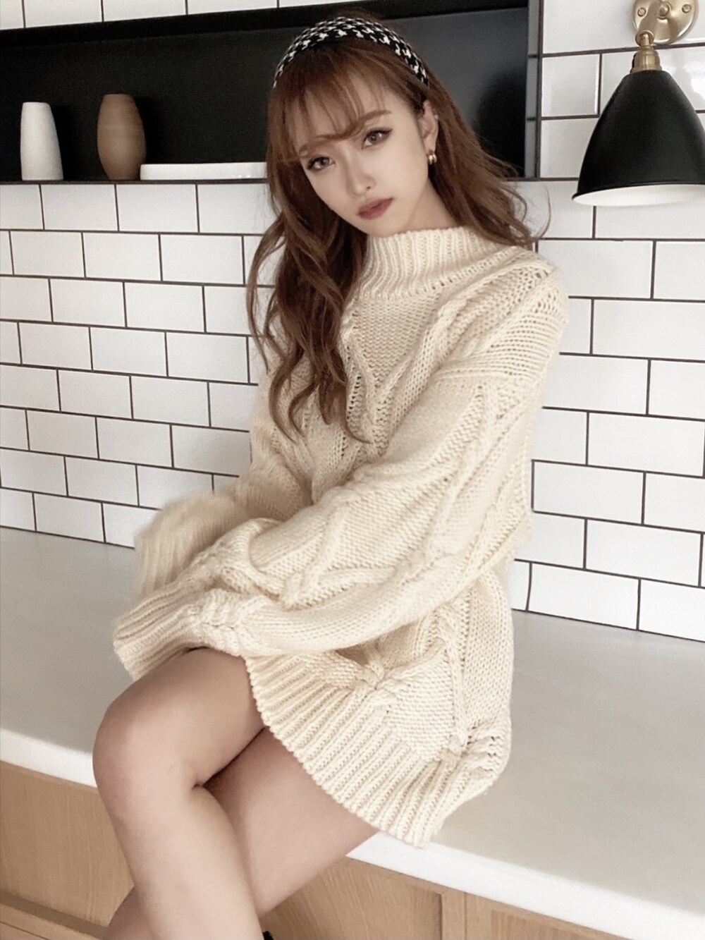 ブラック系のブーツ、ホワイト系のニット/セーターを着用したレディースの秋コーディネートの2枚目の写真