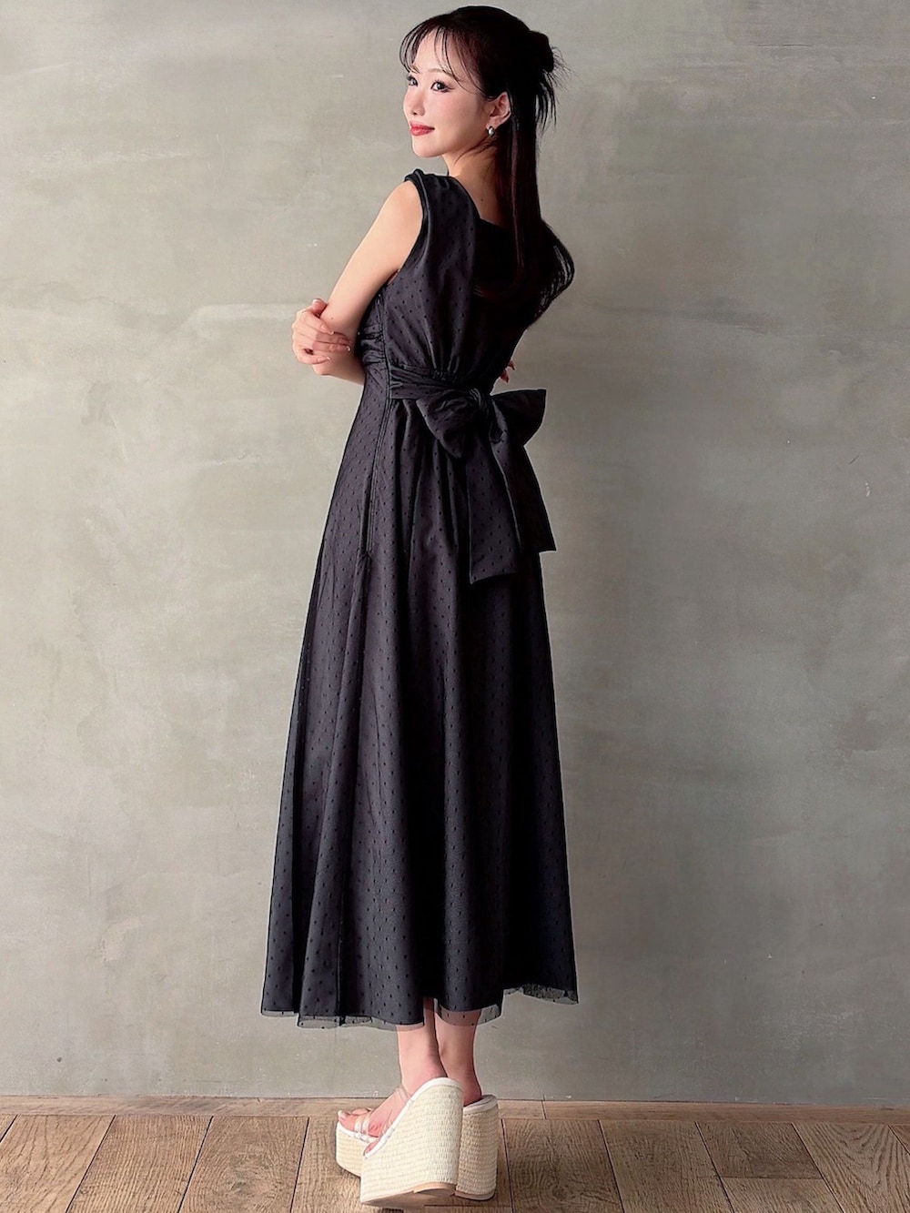 ブラック系のワンピース、ホワイト系のサンダルを着用したレディースの春コーディネートの2枚目の写真