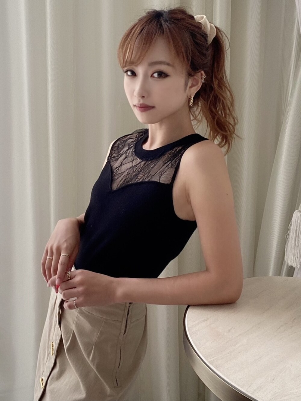 ブラック系のサンダル、ブラック系のニット/セーター、ベージュ系のスカートを着用したレディースの夏コーディネートの3枚目の写真