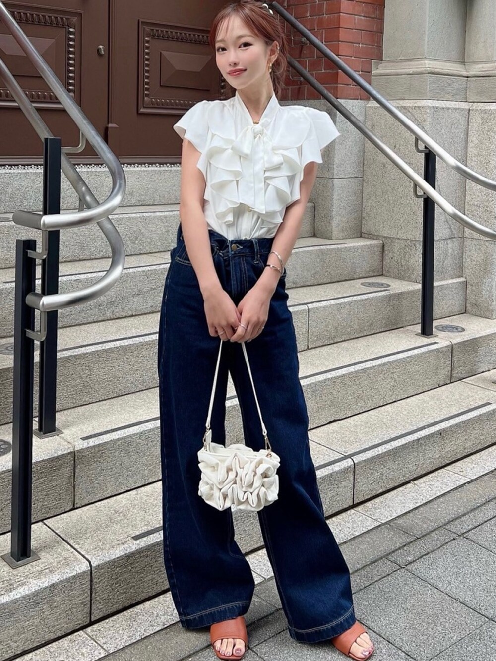ホワイト系のシャツ/ブラウス、ブルー系のデニムパンツ、ホワイト系のハンドバッグを着用したレディースの夏コーディネートの3枚目の写真