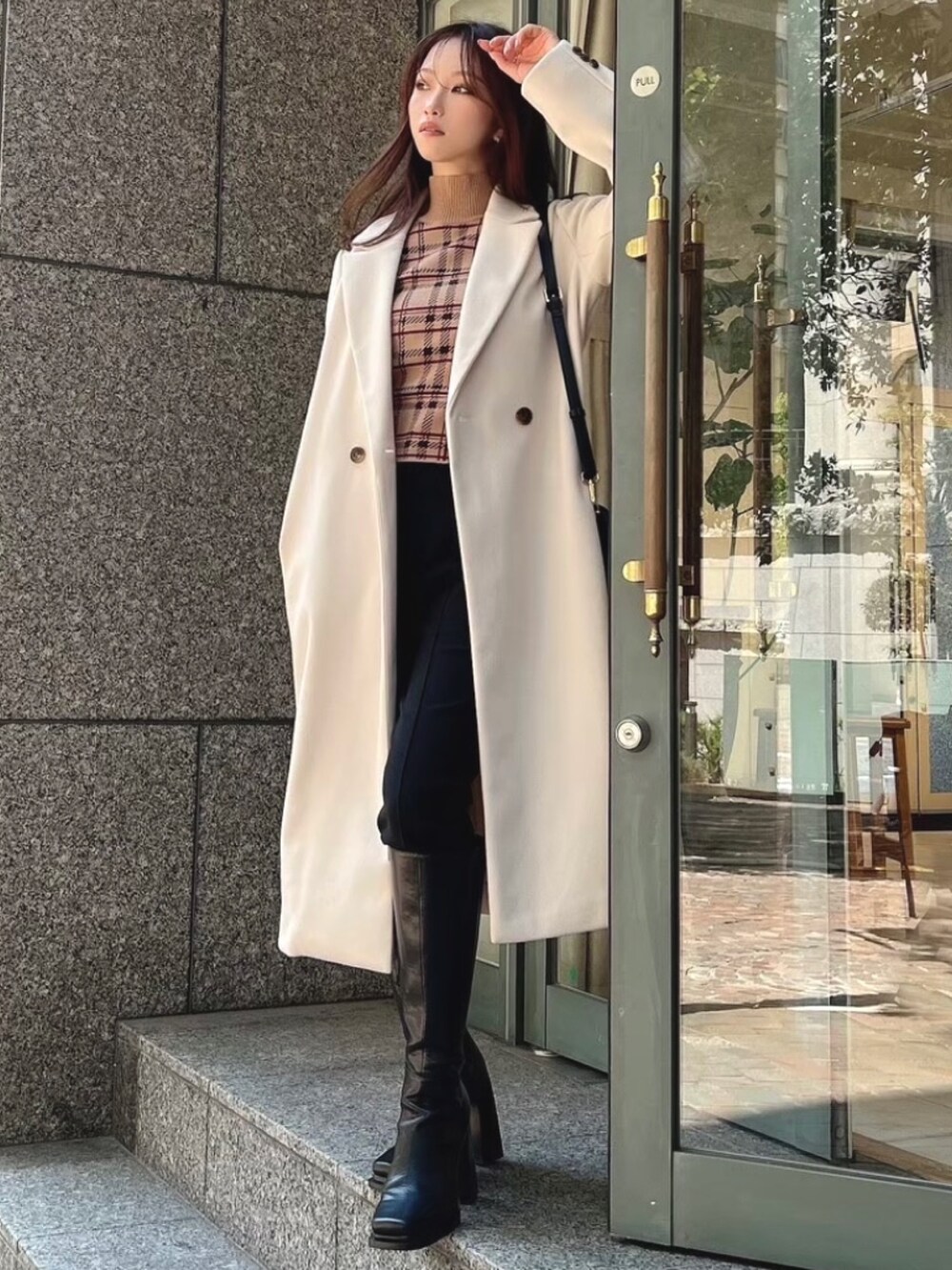 ブラック系のその他パンツ、ブラック系のブーツ、ホワイト系のチェスターコートを着用したレディースの秋コーディネートの2枚目の写真