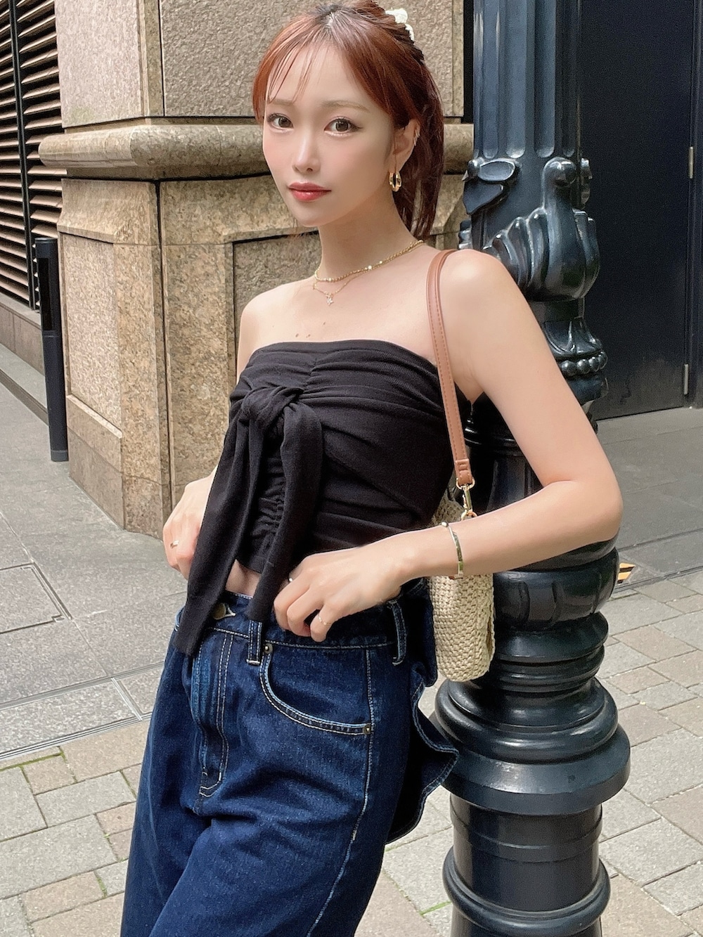 ブラック系のキャミソール、ブルー系のデニムパンツ、ベージュ系のハンドバッグを着用したレディースの夏コーディネートの4枚目の写真