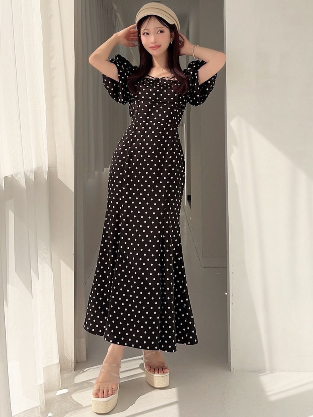 ブラック系のワンピース、ホワイト系のサンダルを着用したレディースの春コーディネートの2枚目の写真